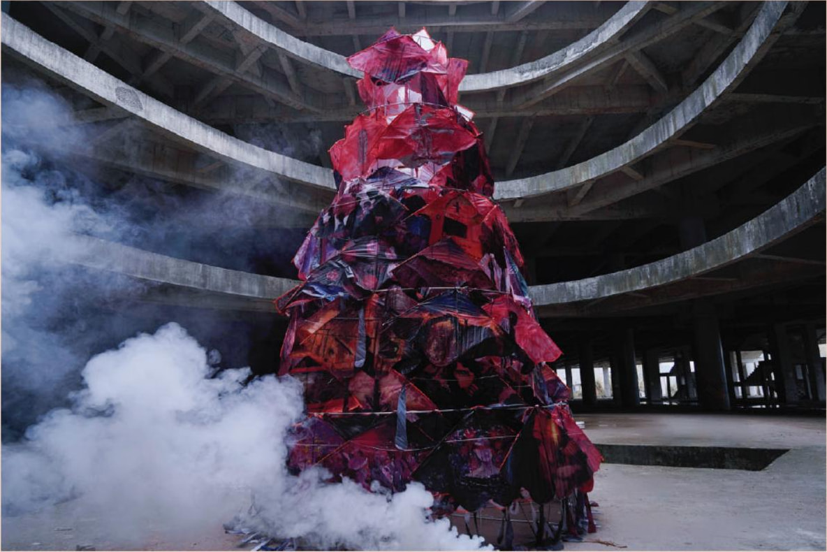 The tower of painted kites standing in drifting smoke beneath the concrete dome of a derelict rotunda